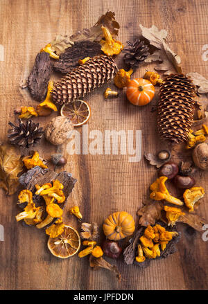 Autumn decorative frame with mushrooms, acorns, pumpkins,dried leaves ,pine cones on wooden background with copy space Stock Photo