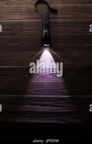 Included flashlight on wooden texture Stock Photo