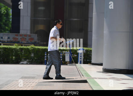 Chongqing, China. 1st Aug, 2017. A blind person walks on blind sidewalk in Jiangbei District of Chongqing, southwest China, Aug. 1, 2017. Chongqing improved the accessibility facilities recently so as to build a better city for disabled people. Credit: Wang Quanchao/Xinhua/Alamy Live News Stock Photo