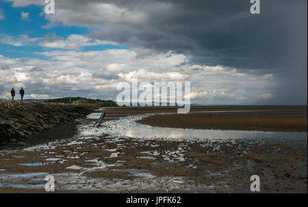 Sunny Summer weather and dramatic dark clouds with intermittent heavy showers over Firth of Forth tidal causeway, Cramond, Edinburgh, Scotland, UK Stock Photo