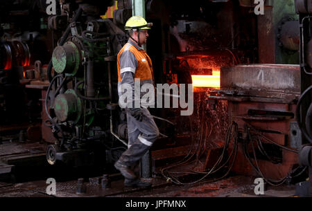 A rolling mill in a metallurgical plant of the ArcelorMittal Ostrava is seen during an extremely hot day in Ostrava, Czech Republic, on August 1, 2017. At the time of heat, workers working in ArcelorMittal Ostrava's hot factories are exposed to excessive working temperatures. In the rolling mill operation its hot stamped plates with a temperature of up to 1200 degrees of Celsius. Employees therefore have a more frequent break mode that they can spend in air-conditioned areas. The company also provides them with more beverages. (CTK Photo/Petr Sznapka) Stock Photo