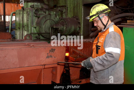 A rolling mill in a metallurgical plant of the ArcelorMittal Ostrava is seen during an extremely hot day in Ostrava, Czech Republic, on August 1, 2017. At the time of heat, workers working in ArcelorMittal Ostrava's hot factories are exposed to excessive working temperatures. In the rolling mill operation its hot stamped plates with a temperature of up to 1200 degrees of Celsius. Employees therefore have a more frequent break mode that they can spend in air-conditioned areas. The company also provides them with more beverages. (CTK Photo/Petr Sznapka) Stock Photo