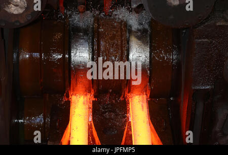 A rolling mill in a metallurgical plant of the ArcelorMittal Ostrava is seen during an extremely hot day in Ostrava, Czech Republic, on August 1, 2017. At the time of heat, workers working in ArcelorMittal Ostrava's hot factories are exposed to excessive working temperatures. In the rolling mill operation its hot stamped plates with a temperature of up to 1200 degrees of Celsius. Employees therefore have a more frequent break mode that they can spend in air-conditioned areas. The company also provides them with more beverages. (CTK Photo/Petr Sznapka) Stock Photo