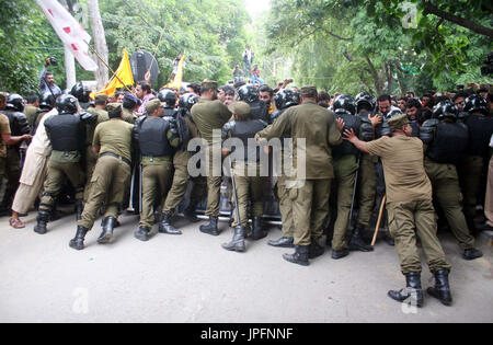 Police officials restore baton charge and open water canon to repel protesters moving towards Red Zone during protest demonstration of Young Doctors Association (YDA) against Secretary Heath Department, near Governor House at Mall road in Lahore on Tuesday, August 01, 2017. Stock Photo