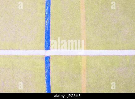 Worn out plastic hairy carpet on outside hanball court. Floor of sports playground with colorful marking lines. Stock Photo