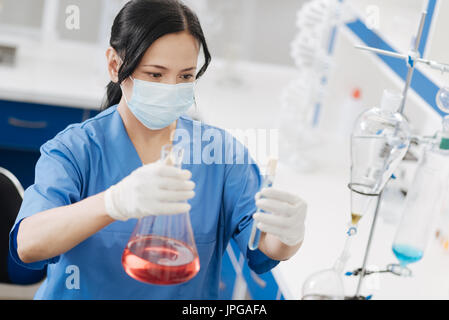 Pleasant serious woman doing a scientific experiment Stock Photo