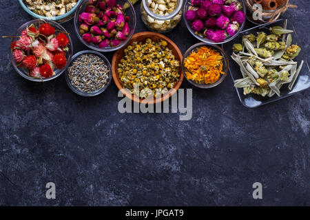 Assortment of dry flower tea over black slate stone with copy space Stock Photo