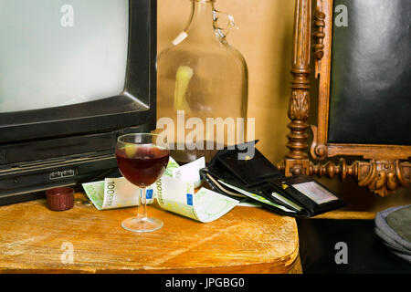 Wine glass and open leather wallet with european currency laid on the table in a living room Stock Photo