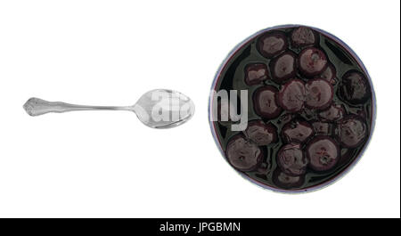 An opened large can of blueberries in light syrup with a small spoon to the side isolated on a white background. Stock Photo