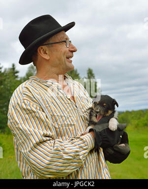 Middle-aged man with puppy in his hands. Portrait Stock Photo