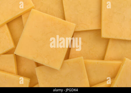 Top close view of several square slices of gouda cheese. Stock Photo