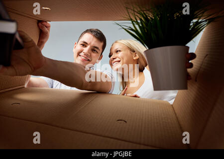 A young couple unpacks boxes. Stock Photo
