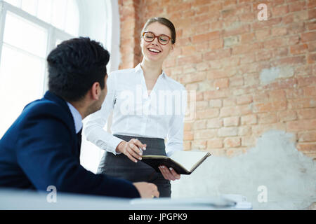 Successful managers discussing new ideas while preparing for business conference Stock Photo