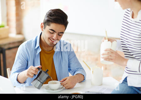 Young colleagues having lunch break at workplace Stock Photo