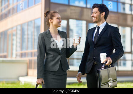 Two young entrepreneurs having talk while walking in the city Stock Photo