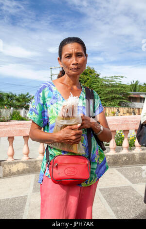 Portrait of a Filipino woman who sells hand-made votive candles outside her church in Bogo City, Cebu Island, Philippines. Stock Photo