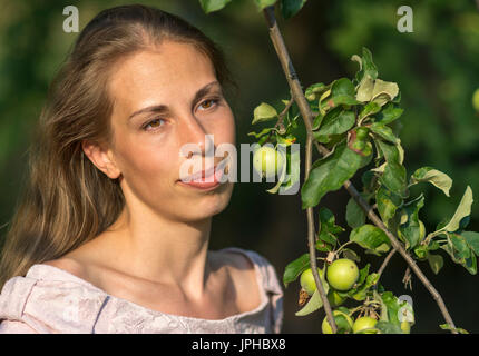 Portrait of a beautiful woman with apple tree branch with apples Stock Photo