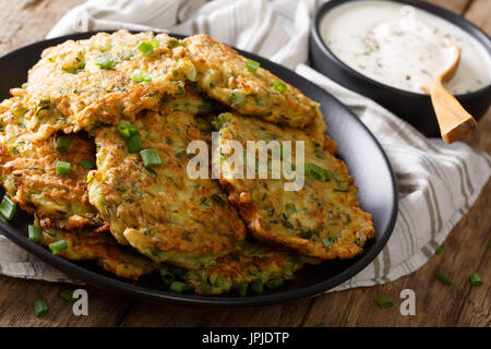 Freshly cooked Zucchini pancakes with sour cream close-up on the table. horizontal Stock Photo