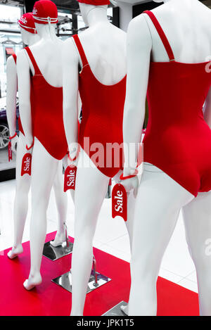 A series of mannequins in red swimsuits.Sale Stock Photo