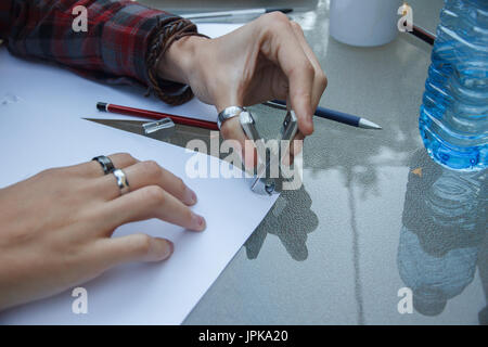 Photo of close up of a hands removing a staple from some documents with a staple remover. Stock Photo