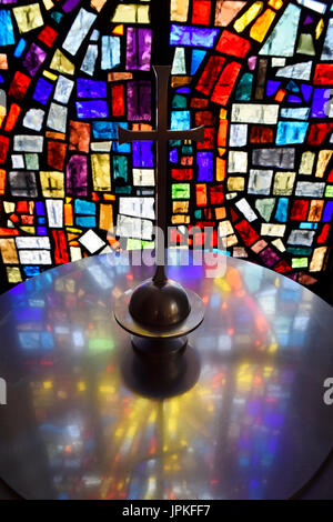 Abstract colors in a stained glass window mosaic at a baptismal font with cross in a Toronto Roman Catholic church Stock Photo