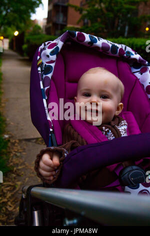 Cute little baby in stroller on light background Stock Photo - Alamy