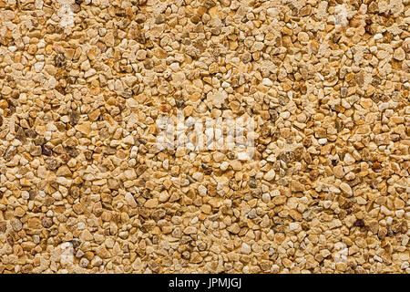 Wall texture, uneven grainy background, colorful pebbles, drake stones, brown, beige, yellow, grungy texture, pattern Stock Photo