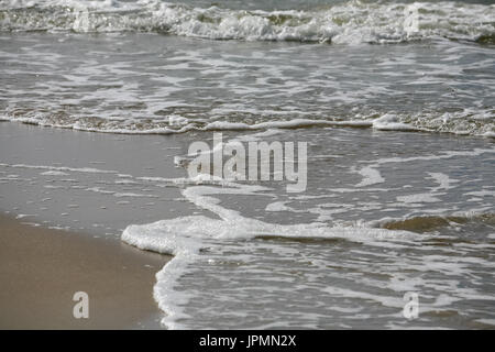 Soft wave of waters of Baltic Sea on sandy beach in Kolobrzeg in Poland. This view creates a seaside background Stock Photo