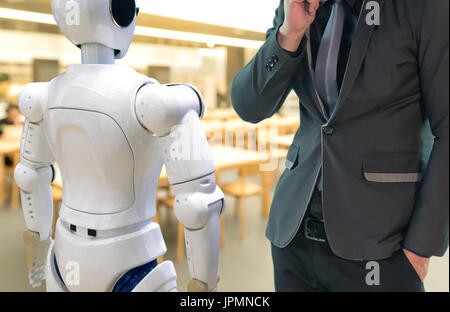 Artificial intelligence , ai concept. Businessman suit use self-driving robot assistant , robo-advisor in library to search for books. Stock Photo