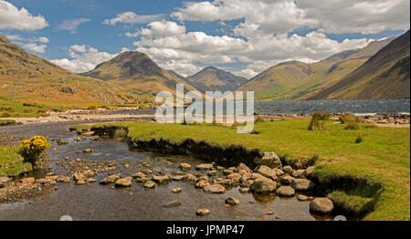 Panoramic view of Wastwater, vast lake hemmed by barren hills and mountain peaks, in Lake District, Cumbria, England under blue sky Stock Photo