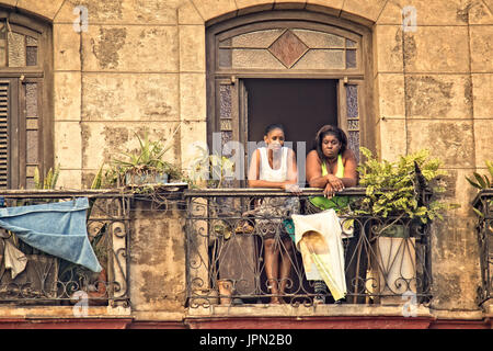 Two Cuban woman stand on an apartment balcony in Havana, Cuba. Stock Photo