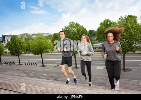 Young people running upstairs on city stairs Stock Photo