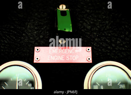 An old emergency engine stop switch with a green cover and guages. Stock Photo