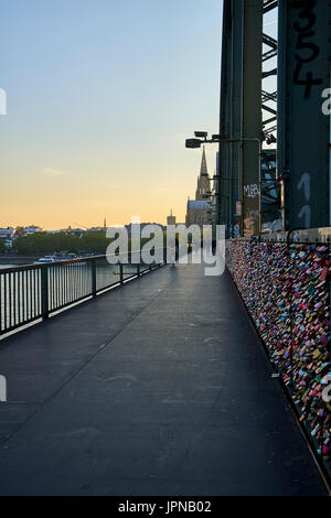 Cologne/Germany - May 10, 2017: Hohenzollern Bridge across the Rhine river with tons of love locks leading towards Cologne Cathedral Stock Photo