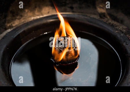 Oil candle in a buddhist temple Stock Photo