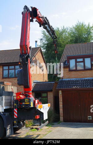 And out she comes, a large Henry Milnes Lathe is lifted from the rear of a property out througha gap between houses to the waiting lorry for transport Stock Photo