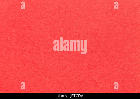 Texture of old bright red paper closeup. Structure of a dense cardboard. The carmine background. Stock Photo