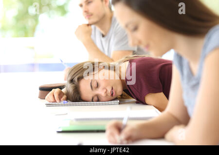 Tired student sleeping during a class in a classroom Stock Photo