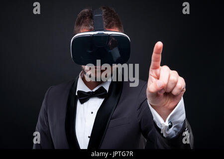 Young exclusive man wearing vr glasses and touching with finger on invisible screen Stock Photo