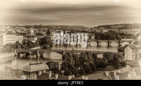 Historic bridges of Prague at the golden hour photographed from Letna park. Vintage black and white processed. Stock Photo