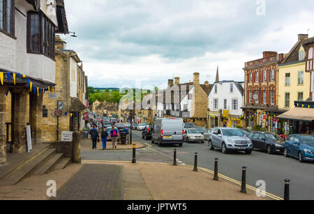 Tourists make thier way along the Hill Burfords main street Oxfordshire England UK Stock Photo