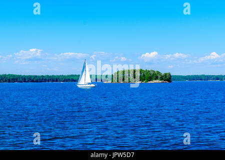 View of a sail boat with Kotiluoto island in the backgound, in Helsinki, Finland Stock Photo