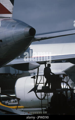 refueller with a fuel-hose attached to the underside of the wing of a Boeing 767-200 parked and an APU exhaust outlet Stock Photo