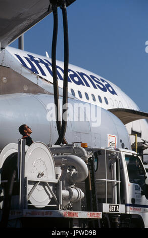 Lufthansa Airbus A340 refueller by fuel-hoses attached to underside of the wing from a refuelling-truck with a CFM56-5 engine-cowling Stock Photo