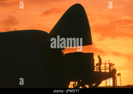 cargo being loaded into open nose cargo door of a Southern Air Transport Boeing 747 at dusk Stock Photo