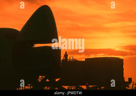 cargo being loaded into open nose cargo door of a Southern Air Transport Boeing 747 at dusk Stock Photo