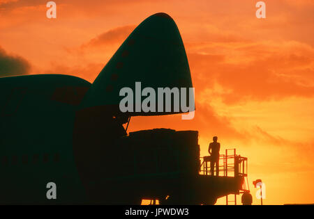 cargo being loaded into open nose cargo door of a Southern Air Transport Boeing 747 at dusk Stock Photo