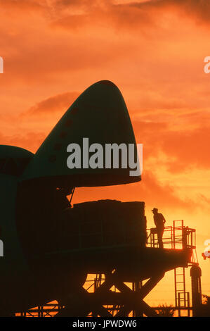 cargo being loaded into open nose cargo door of a Southern Air Transport Boeing 747 at dusk Stock Photo