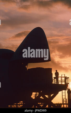 cargo being loaded into open nose cargo door of a Southern Air Transport Boeing 747 at dusk Stock Photo