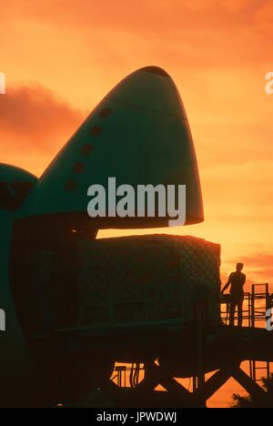 cargo being loaded into open nose cargo door of a Southern Air Transport Boeing 747 at dusk Stock Photo